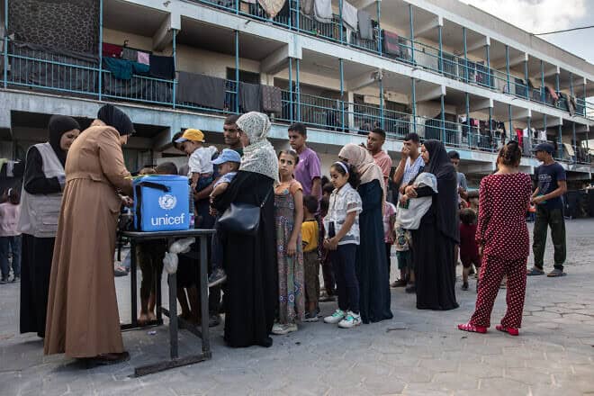 People queue with their children for polio vaccinations at a makeshift camp for those displaced by conflict in a school run by UNRWA in Khan Younis in the southern Gaza Strip on Sept. 5, 2024. Photo by Bashar Taleb/AFP via Getty Images.