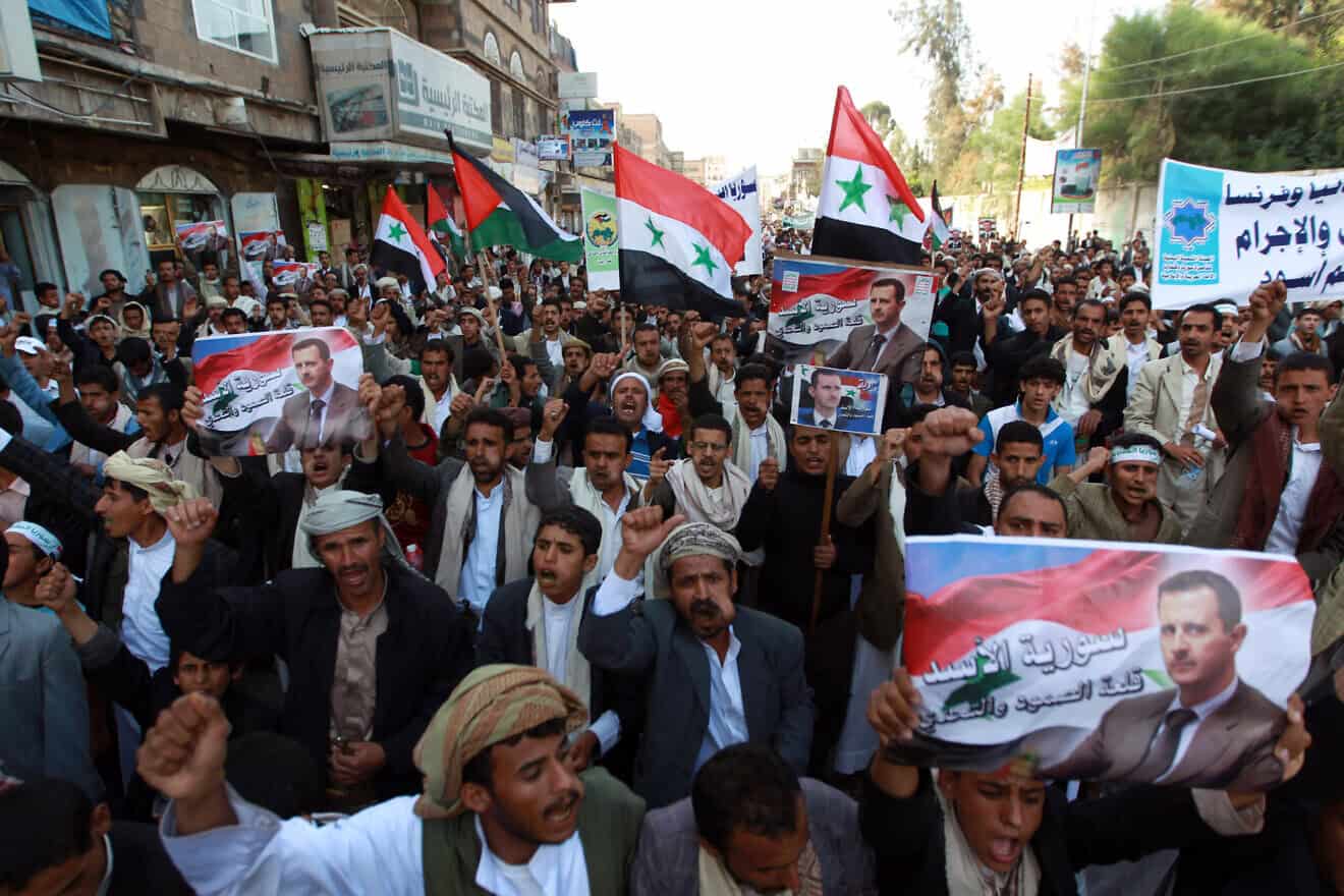 Houthi supports hold up posters of Syrian President Bashar Assad during a demonstration in Sanaa on Aug. 30, 2013. Photo by Mohammed Huwais/AFP via Getty Images.