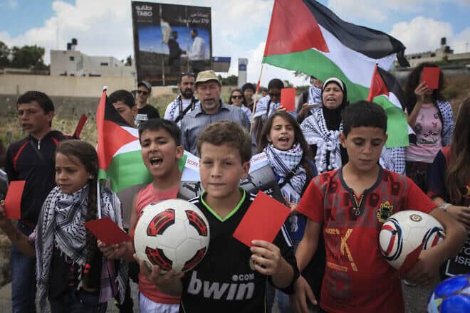 Palestinian youth rally in the West Bank village of Nabi Saleh, near Ramallah in the West Bank, in support of a move to have Israel suspended from FIFA, the International Federation of Association Football, May 29, 2015. Photo by STR/Flash90.