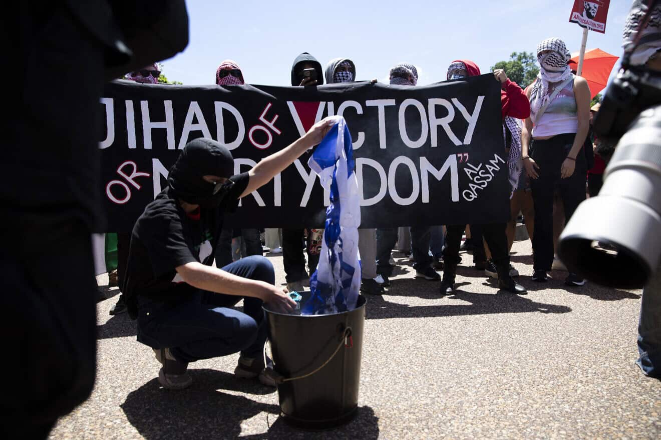 A pro-Palestinian protester is burning an Israeli flag in front of the White House during anti-Israel, anti-Western rally on June 8, 2024. Photo by Aashish Kiphayet/Middle East Images/AFP via Getty Images.