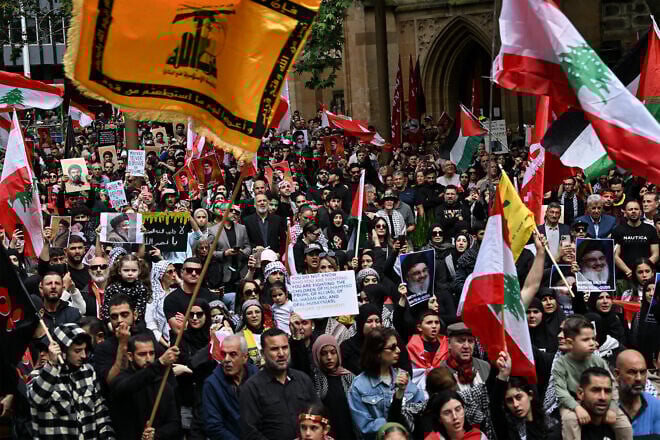 A huge crowd of anti-Israel protesters hold flags and pictures of Hassan Nasrallah, late leader of the Hezbollah terror group, and a Hezbollah flag in Sydney on Sept. 29, 2024. Photo by Saeed Khan/AFP via Getty Images.