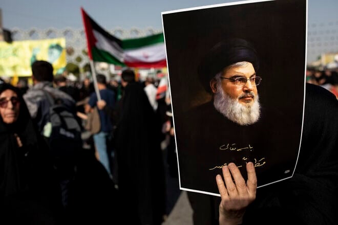 An Iranian demonstrator carries a poster of slain Hezbollah leader Hassan Nasrallah in a rally in Tehran commemorating him, Oct. 2, 2024. Photo by Majid Saeedi/Getty Images.