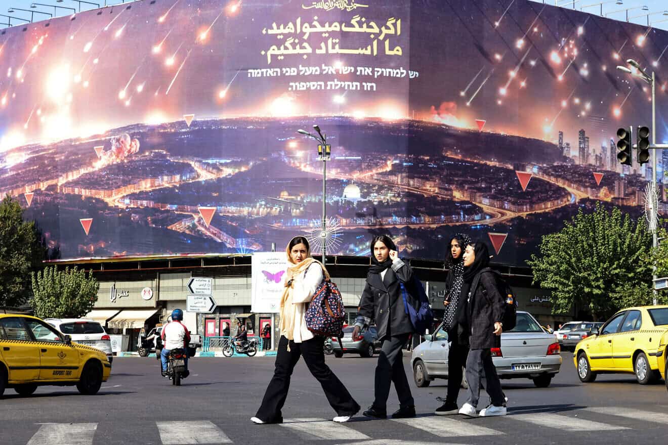 Women walk past an anti-Israel billboard covering the facade of a building in Tehran on Oct. 26, 2024. Photo by Atta Kenare/AFP via Getty Images.