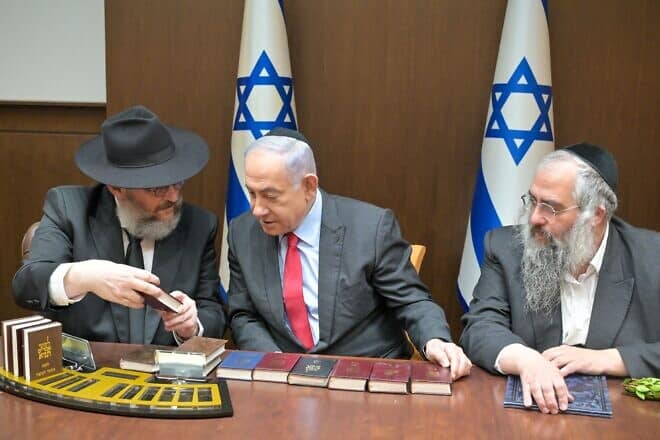 Israeli Prime Minister Benjamin Netanyahu receives a copy of the "Tanya," an early work of Chassidic philosophy, printed in various places in Lebanon during the First Lebanon War in 1982, Oct. 15, 2024. Credit: Koby Gideon/GPO.