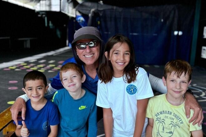 Coach Ronen Morali poses with children enrolled in the “Home Away from Home” three-day tennis camp. Photo by Alam Ibrahim.