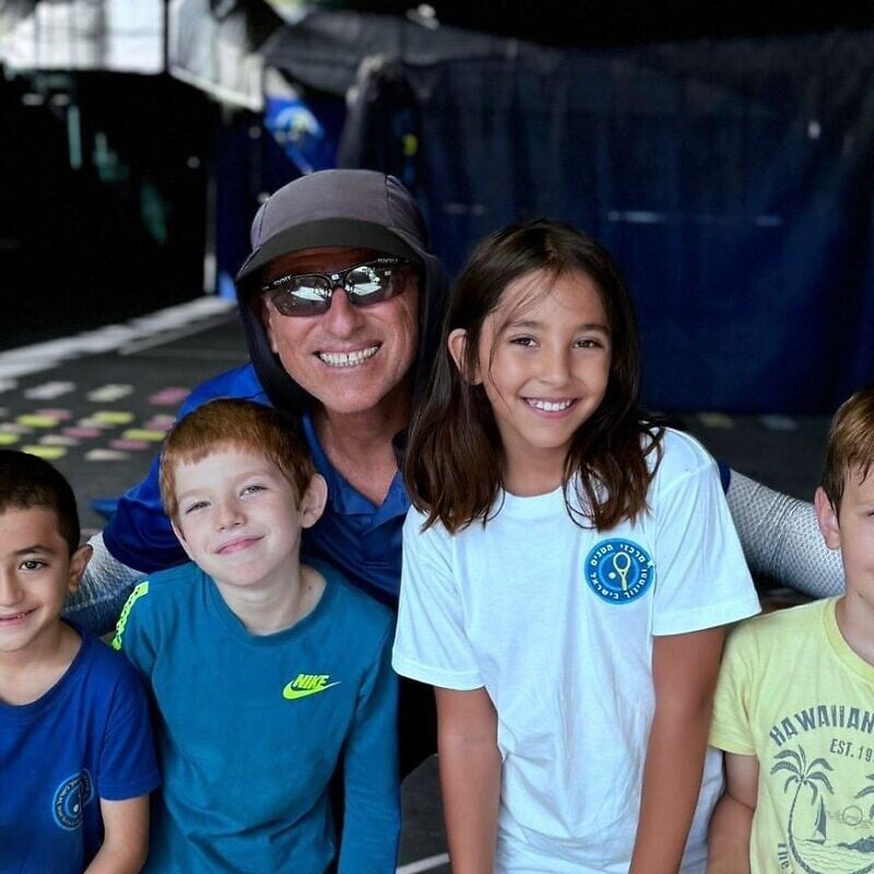 Coach Ronen Morali poses with children enrolled in the “Home Away from Home” three-day tennis camp. Photo by Alam Ibrahim.