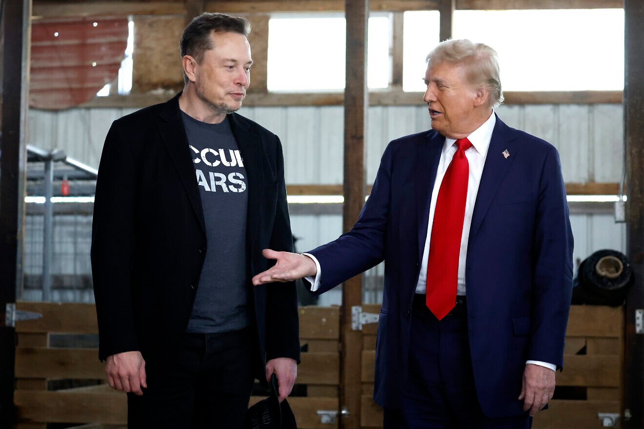 Republican presidential nominee, former President Donald Trump offers his hand to Elon Musk back stage during a campaign rally at the Butler Farm Show grounds on Oct. 5, 2024 in Butler, Pa. Photo by Anna Moneymaker/Getty Images.