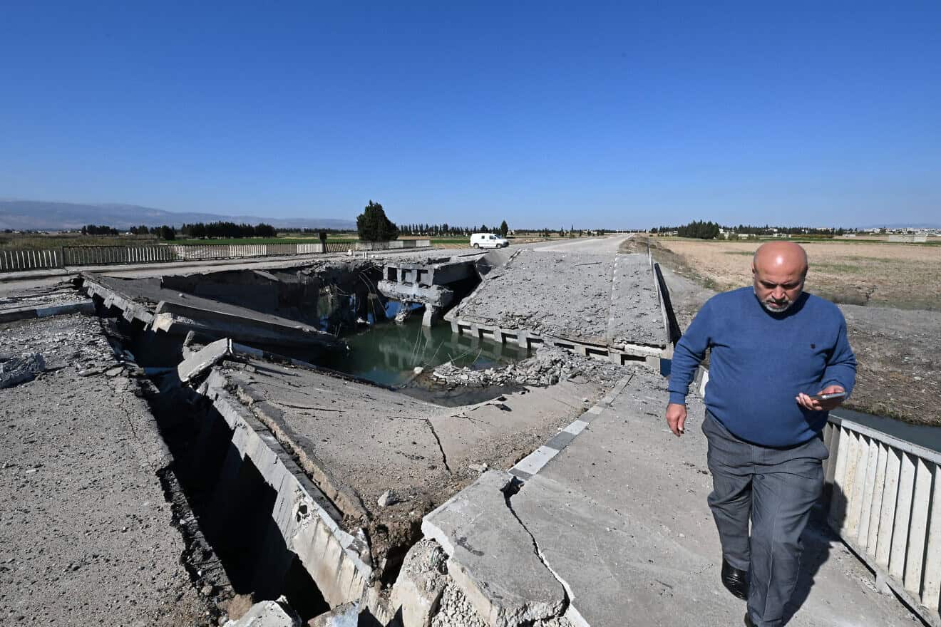 A man crosses a bridge damaged by an Israeli strike near the Syrian village of Tall al-Nabi Mando in the countryside of Qusayr on Oct. 28, 2024. Photo by Louai Beshara/AFP via Getty Images.