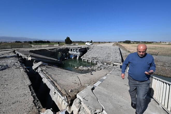 A man crosses a bridge damaged by an Israeli strike near the Syrian village of Tall al-Nabi Mando in the countryside of Qusayr on Oct. 28, 2024. Photo by Louai Beshara/AFP via Getty Images.