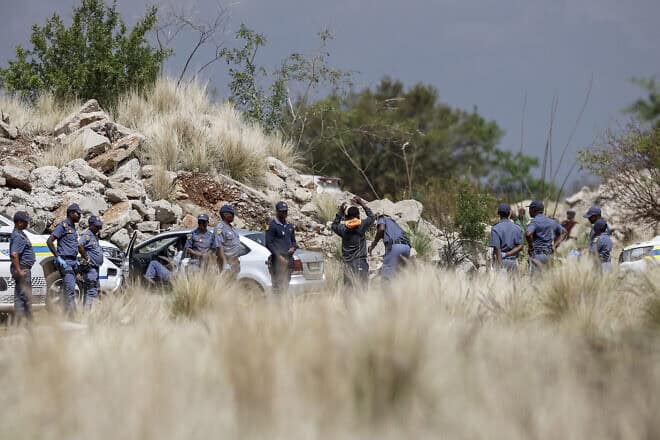 Community members are searched by South African Police Service officers before entering the mine shaft to negotiate with miners underground on Nov. 13, 2024. Photo by Emmanuel Croset/AFP via Getty Images.