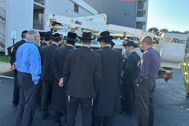 Conference participants explore one of four bucket trucks brought to the hotel for a hands-on seminar. Credit: Courtesy of the Orthodox Union.