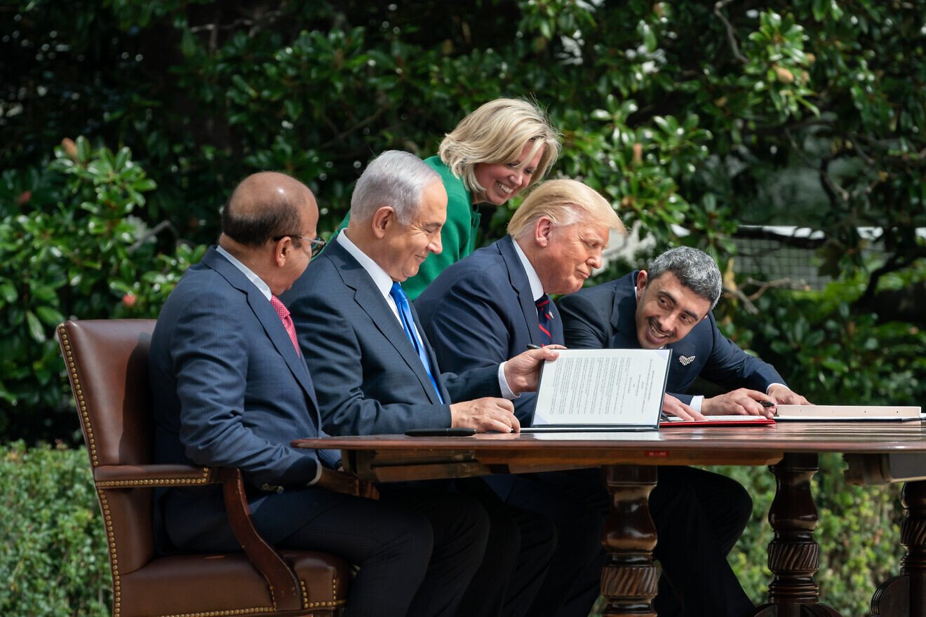 U.S. Chief of Protocol Cam Henderson helps President Donald Trump, Bahraini Foreign Minister Abdullatif bin Rashid Al-Zayani, Israeli Prime Minister Benjamin Netanyahu and Emirati Foreign Affairs Minister Abdullah bin Zayed Al Nahyan with documents during the signing of the Abraham Accords on the South Lawn of the White House, Sept. 15, 2020. Credit: Andrea Hanks/White House.