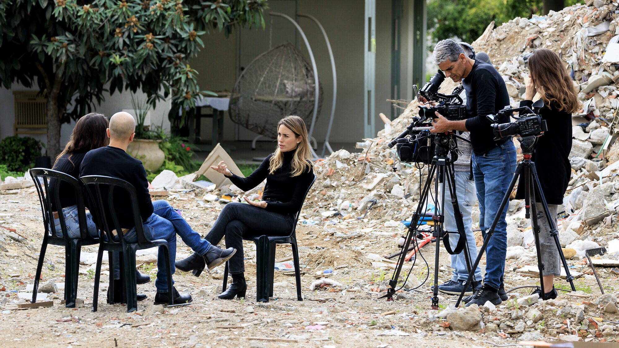 "Channel 12" journalist Adva Dadon backdropped by destruction from the massacre on Oct. 7, 2023, at Kibbutz Be'eri, Jan. 3, 2024. Photo by Moshe Shai/Flash90.