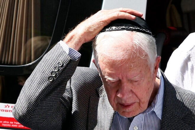Former U.S. President Jimmy Carter puts on a yarmulke before meeting with the religious leader of the Jewish Sephardic community, Rabbi Ovadia Yosef, in Jerusalem on Aug. 25, 2009. Credit: Abir Sultan/Flash90.