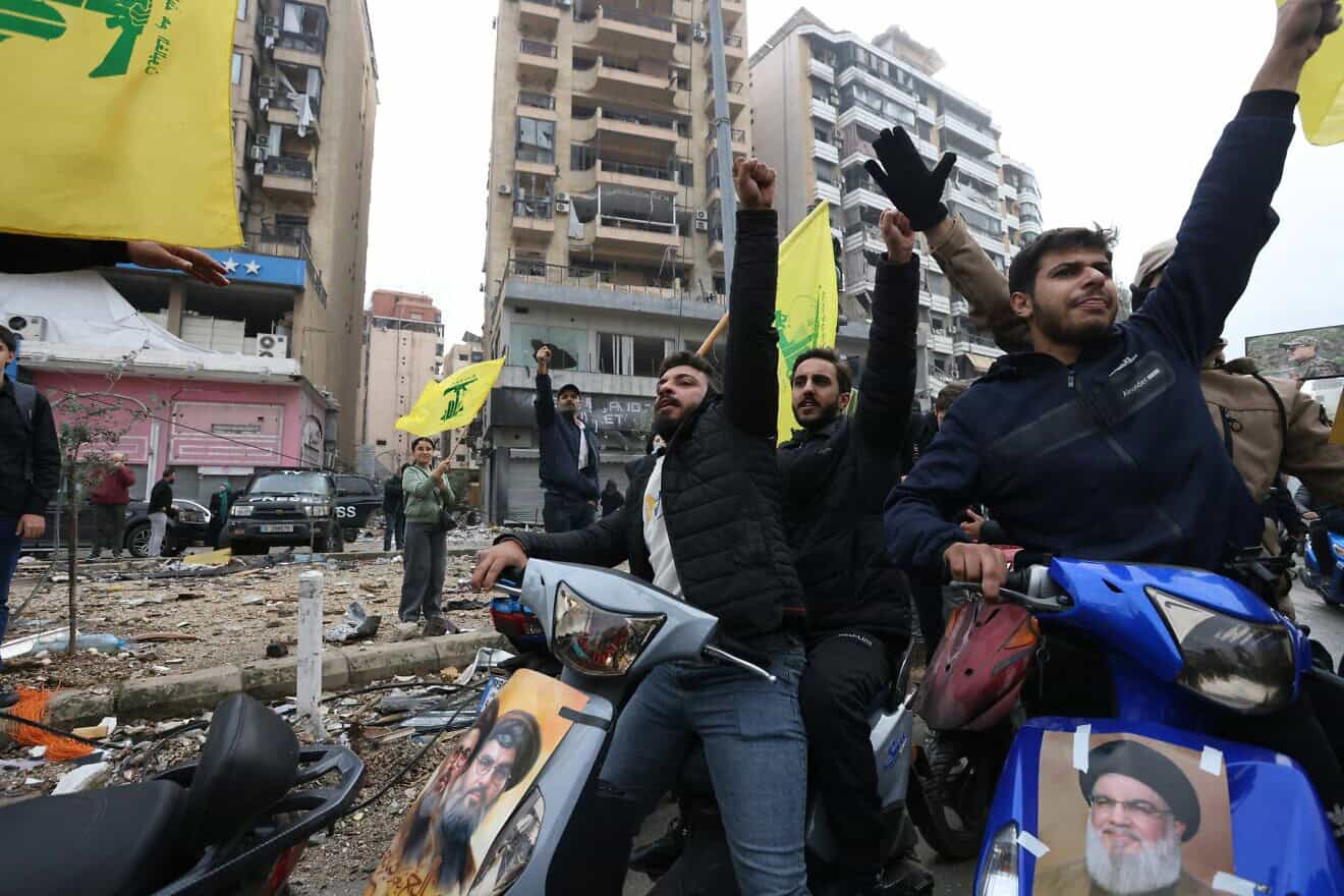 Hezbollah supporters wave the group's yellow flag during a parade on motorbikes while people returned to the area to check their homes in Beirut's southern suburbs on Nov. 27, 2024. Photo by Ibrahim Amro/AFP via Getty Images.