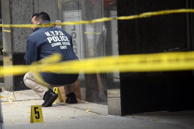 Police place bullet casing markers outside of a Hilton Hotel in Midtown Manhattan where United Healthcare CEO Brian Thompson was fatally shot on Dec. 4, 2024, in New York City. Photo by Spencer Platt/Getty Images.