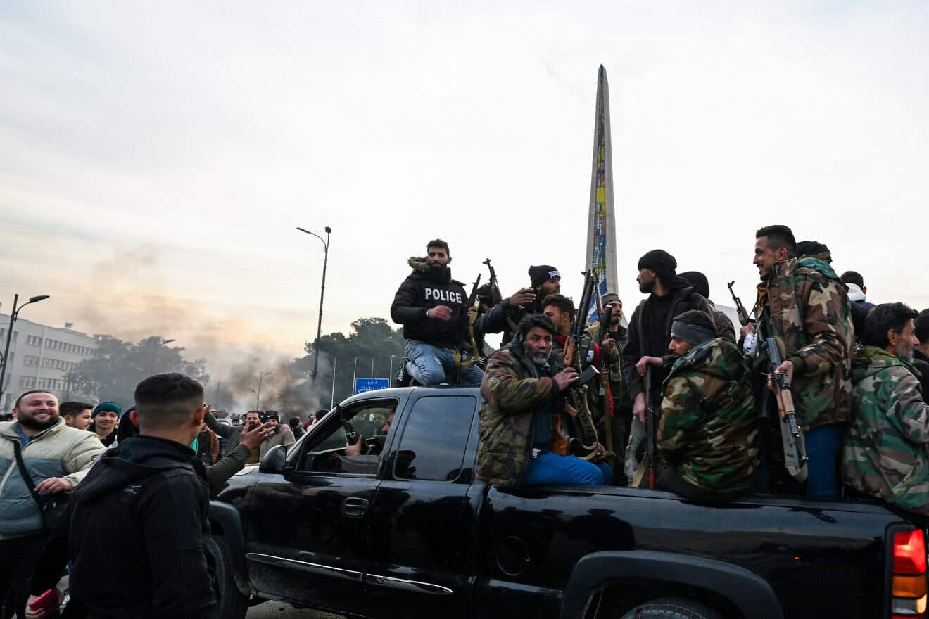 Syrians celebrate with rebel fighters at Umayyad Square in Damascus, Dec. 8, 2024. Photo by Louai Beshara/AFP via Getty Images.