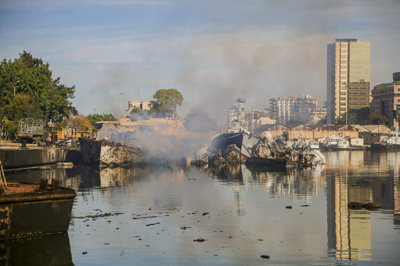 Smoke billows from a Syrian naval ship destroyed in an overnight Israeli attack on the port city of Latakia on Dec. 10, 2024. Photo by Bilal Alhammoud/Middle East Images/AFP via Getty Images.
