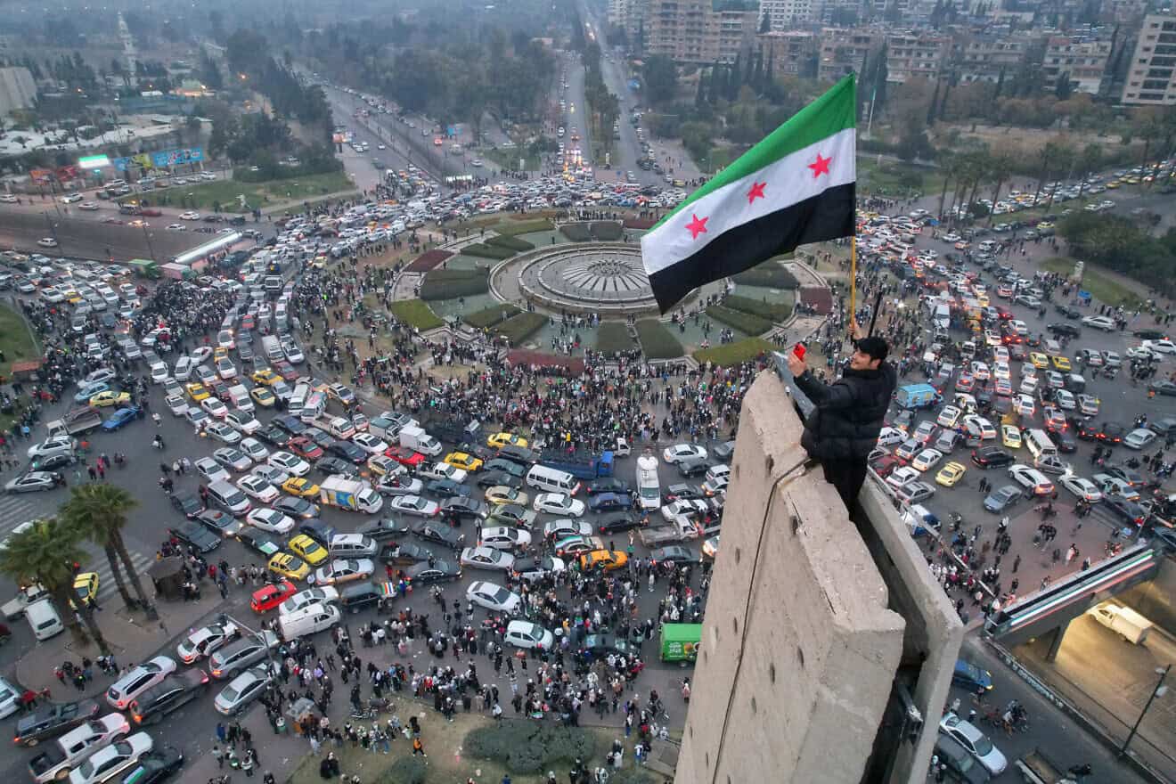 An aerial view shows a Syrian man waving the independence-era Syrian flag at Damascus' central Umayyad Square on Dec. 11, 2024. Photo by Bakr Alkasem/AFP via Getty Images.