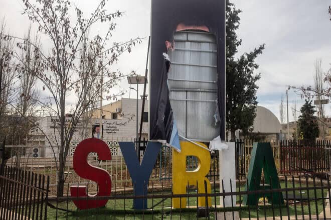 A destroyed poster of former President of Syria Bashar Assad is seen on the side of the highway in Damascus, on Dec. 11, 2024. Photo by Chris McGrath/Getty Images.
