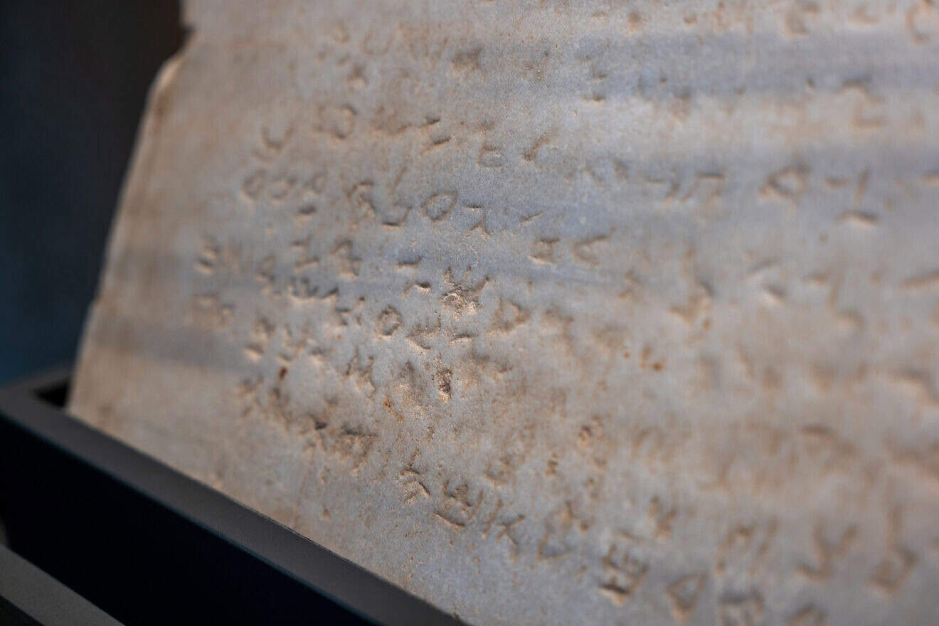 The oldest-known stone tablet inscribed with the Ten Commandments, dating from 300 to 800 C.E., is displayed at Sotheby's auction house on Dec. 9, 2024 in New York City. Inscribed with the commandments in Paleo-Hebrew script, the tablet was discovered during railroad excavations along the southern coast of Israel in 1913. Photo by Spencer Platt/Getty Images.