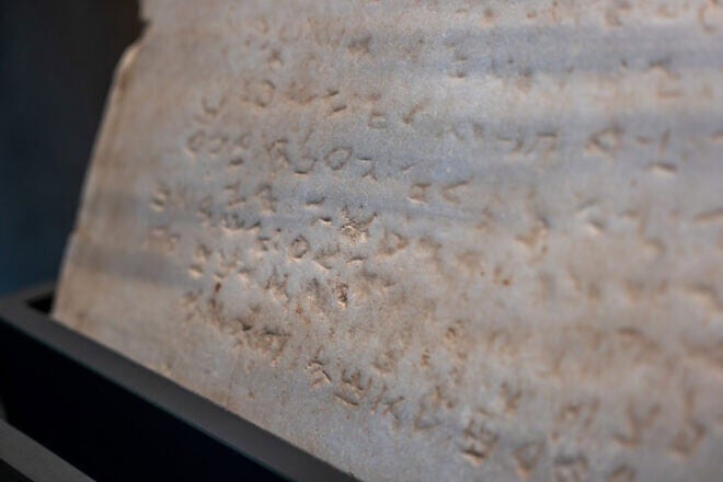 The oldest-known stone tablet inscribed with the Ten Commandments, dating from 300 to 800 C.E., is displayed at Sotheby's auction house on Dec. 9, 2024 in New York City. Inscribed with the commandments in Paleo-Hebrew script, the tablet was discovered during railroad excavations along the southern coast of Israel in 1913. Photo by Spencer Platt/Getty Images.