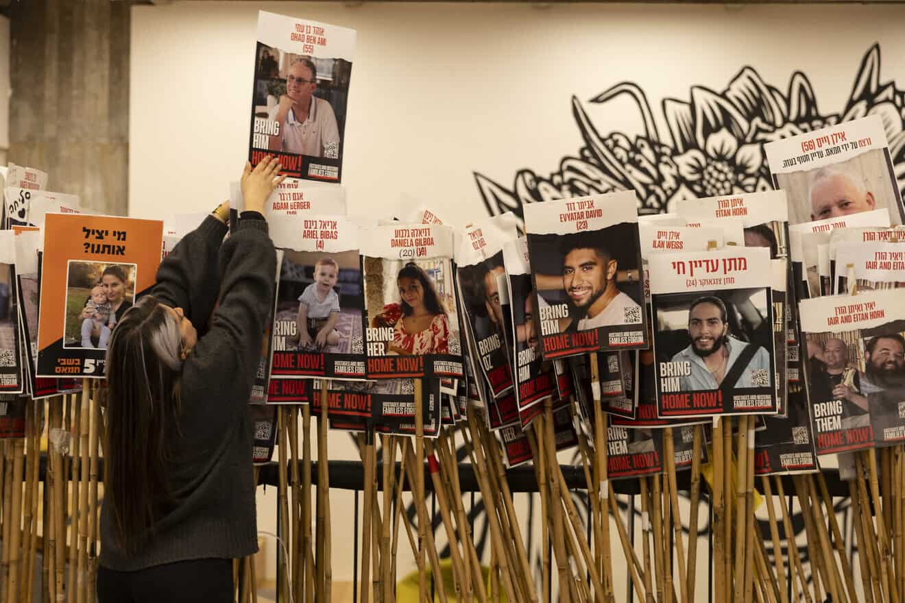 An activist sets up photos of hostages being held in the Gaza Strip before a statement by released hostages in Tel Aviv's "Hostage Square" on Dec. 17, 2024. Photo by Amir Levy/Getty Images.