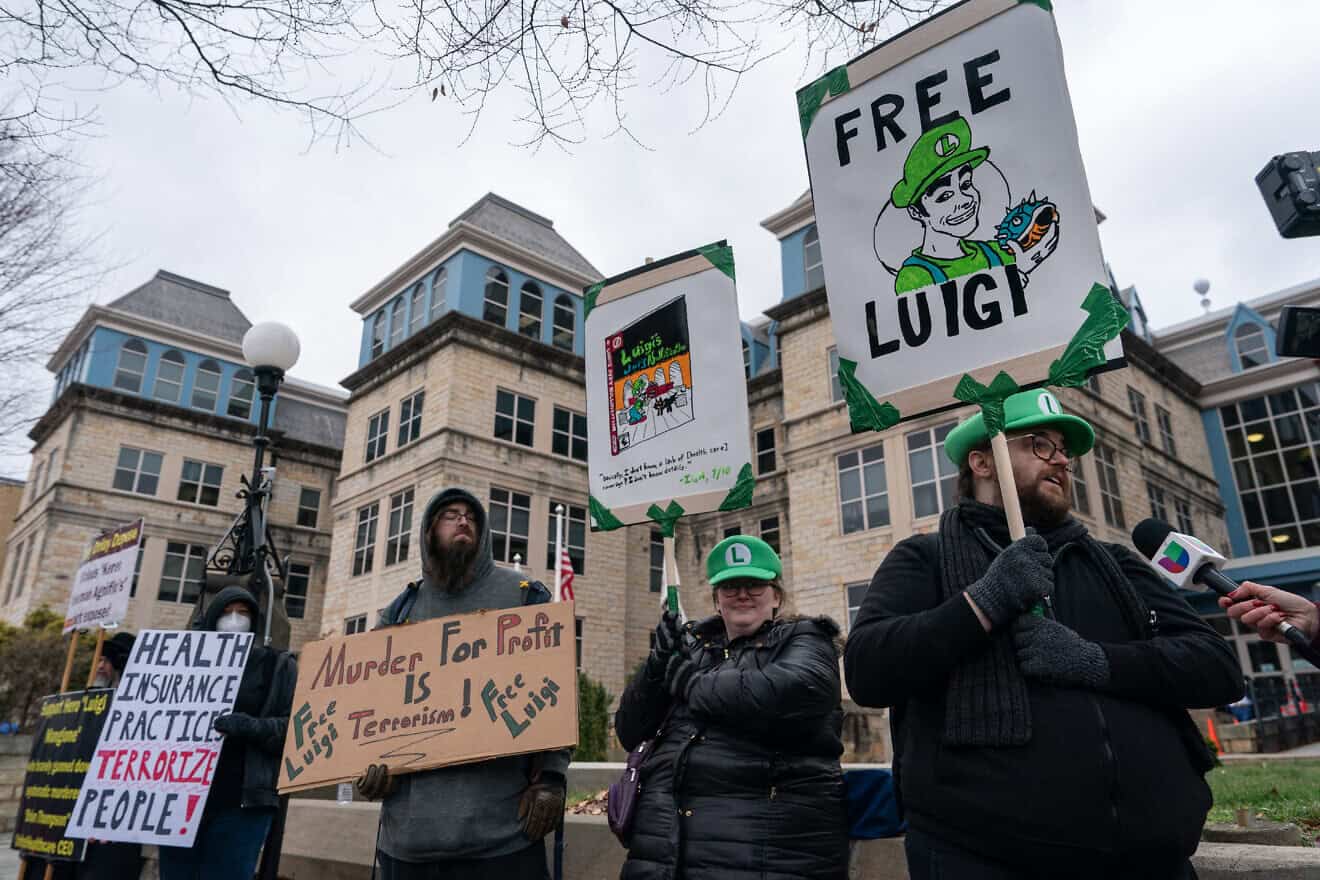 Protesters rally in support of Luigi Mangione, who shot and killed Brian Thompson, CEO of United Healthcare, in New York City on Dec. 4, after he left the Blair County Courthouse in Hollidaysburg, Pa., Dec. 19, 2024. Photo by Adam Gray/AFP via Getty Images.