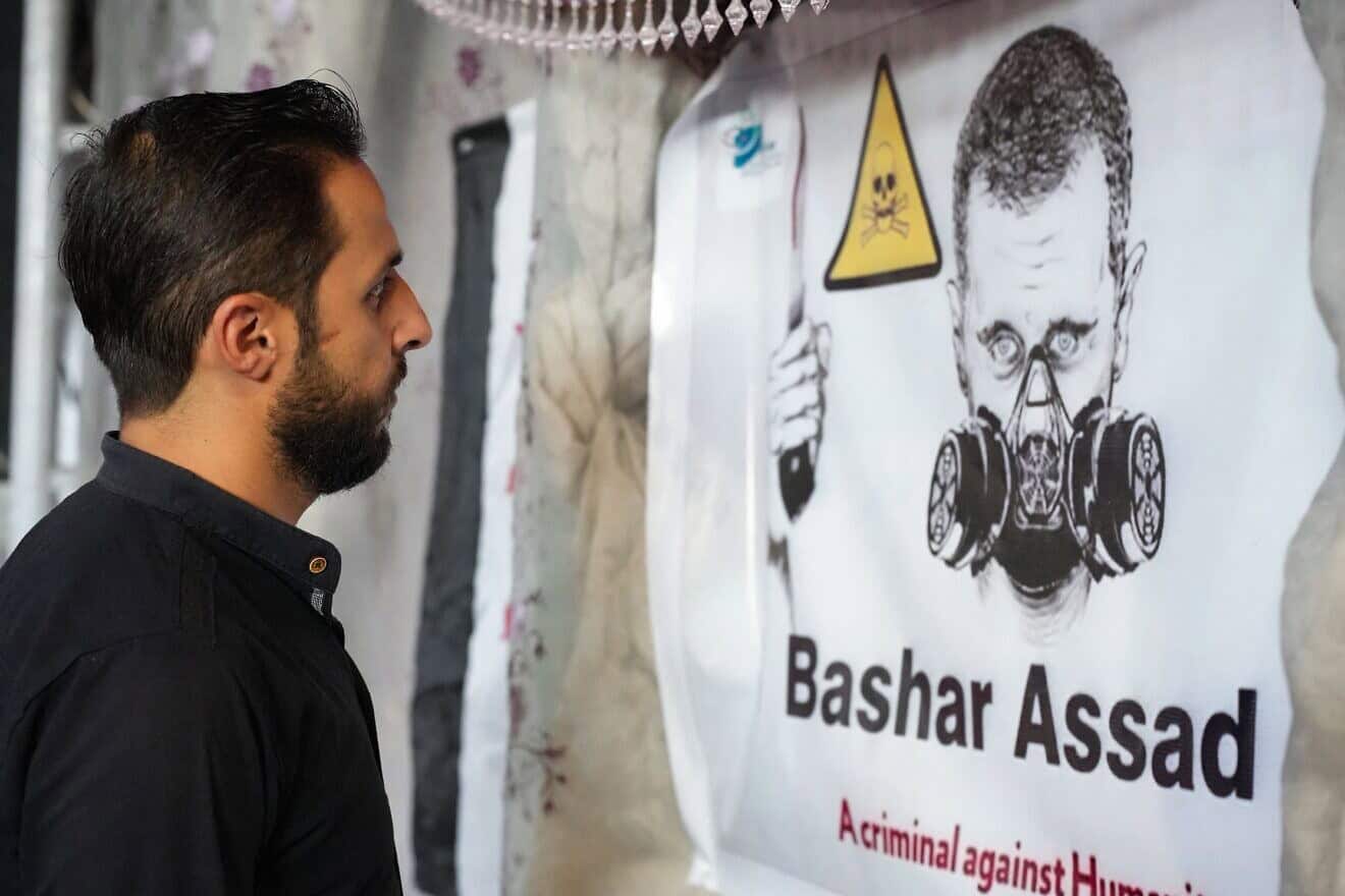 A poster depicts Syrian President Bashar Assad in a gas mask during an event in the rebel-held northern city of Afrin, marking the 10-year anniversary of chemical attacks that killed more than 1,400 people in Ghouta, near the capital, on Aug. 20, 2023. Photo by Rami Al Sayed/AFP via Getty Images.