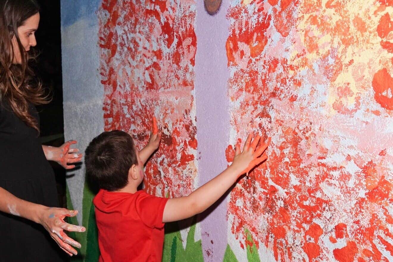 Kibbutz Nir Am community members transform a blank canvas into a vibrant butterfly, each colorful handprint telling a story of unity, creativity, and collective joy. Credit: Courtesy of OU-JLIC.