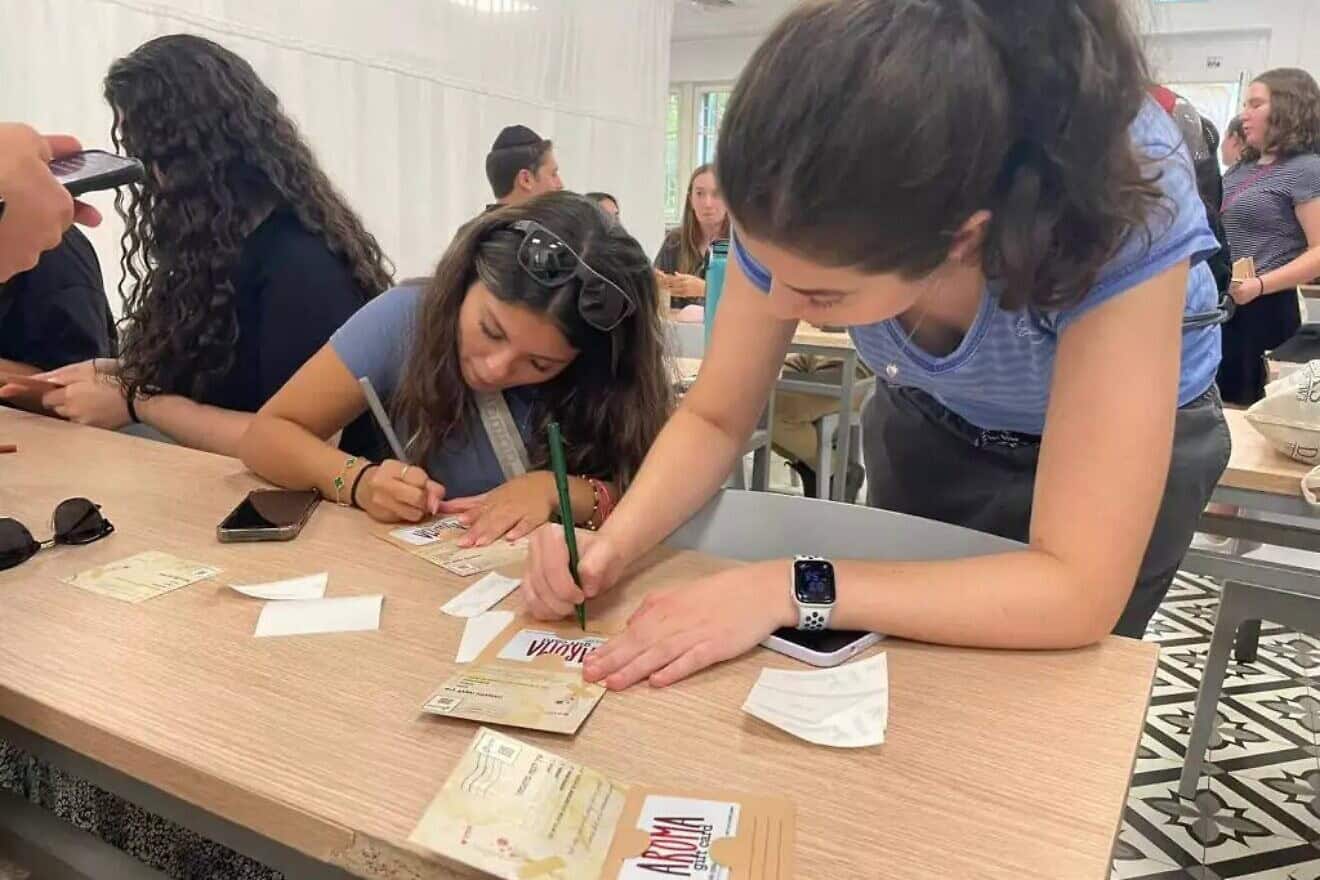 American students write personal messages on gift cards for wives of IDF reservists serving in Gaza and Lebanon. Credit: IS-Resilient.