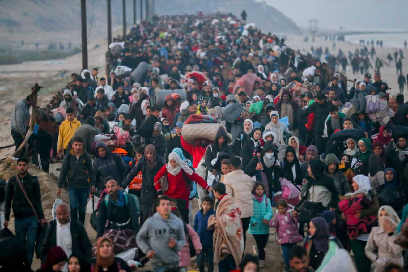Gazans walk north on the al-Rashid Road coastal route to cross the Netzarim Corridor on Jan. 27, 2025. Photo by Youssef Alzanoun/Middle East Images/AFP via Getty Images.