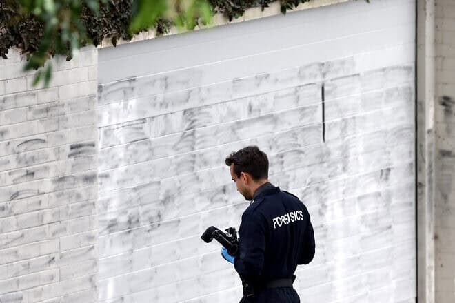 A forensics police officer takes photographs of the wall where anti-Israel graffiti has been removed in the Sydney suburb of Woollahra on Dec. 11, 2024. Photo by David Gray/AFP via Getty Images.