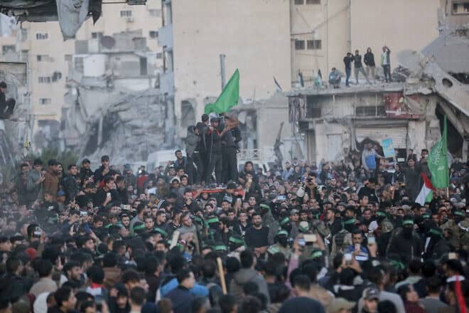 Hamas terrorists escort a Red Cross vehicle to collect Israeli hostages released after a ceasefire agreement between Israel and Hamas took effect, in Gaza City, Jan. 19, 2025. Photo by Abood Abusalama/Middle East Images/AFP via Getty Images.