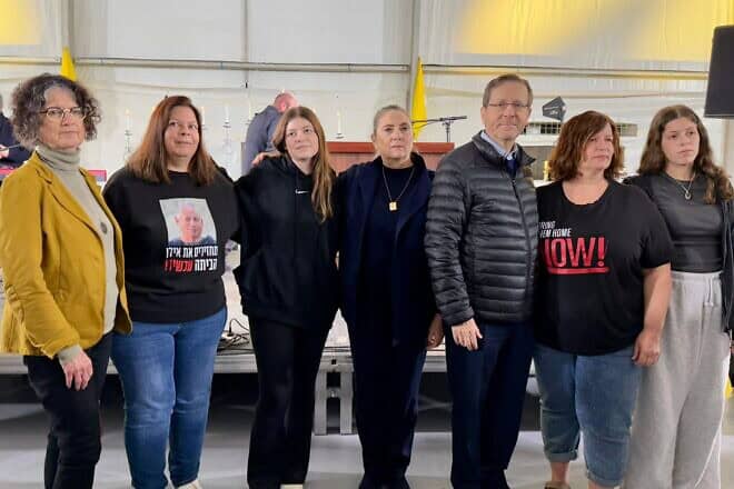 President Isaac Herzog lights the eighth Chanukah candle in Kibbutz Hatzerim together with former Hamas captives, Jan. 1, 2025. Credit: Israeli President's Spokesperson.