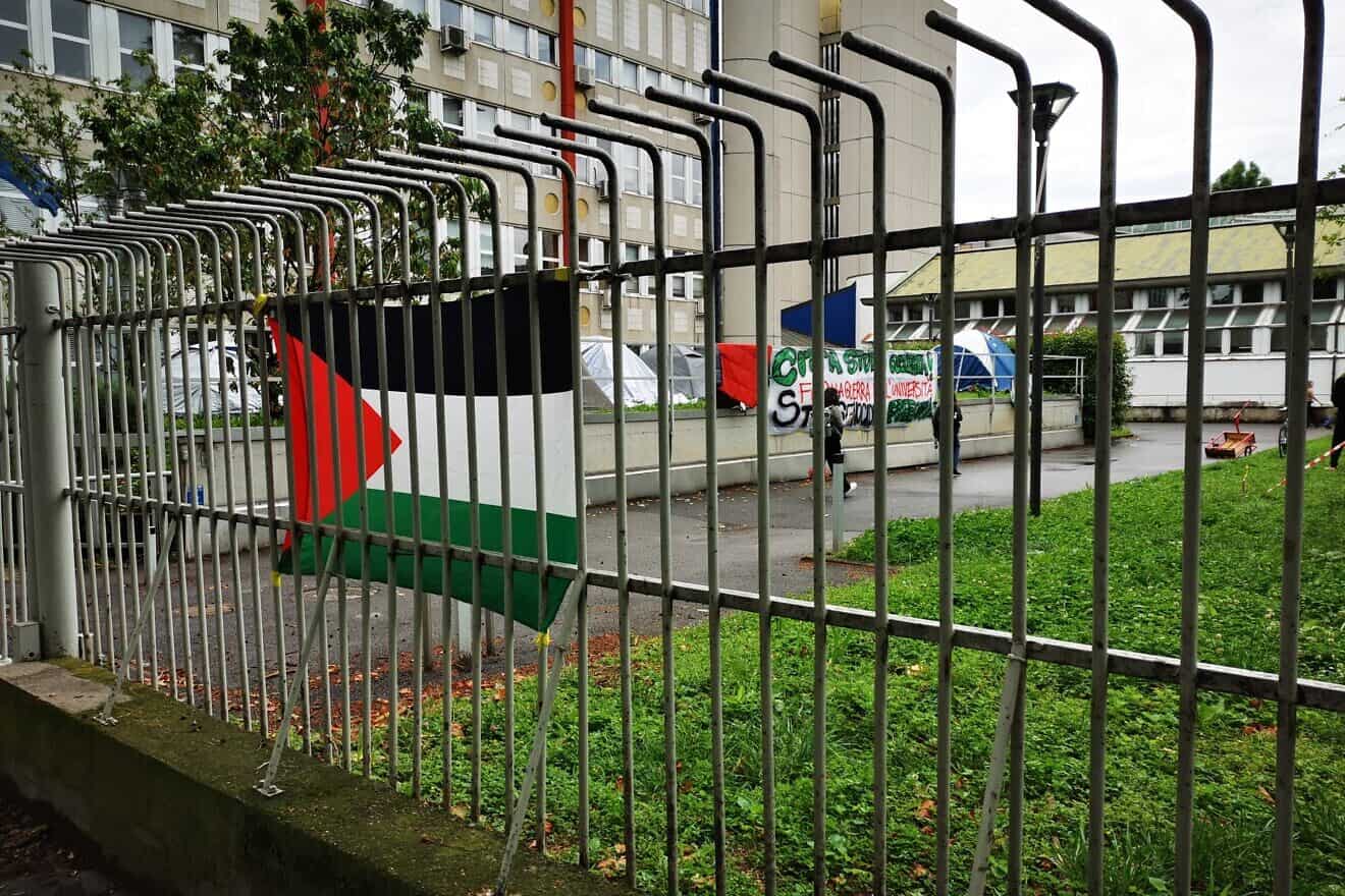 Pro-Palestinian flag and signs at the University of Milan, Italy. Credit: Saggittarius A via Wikimedia Commons.