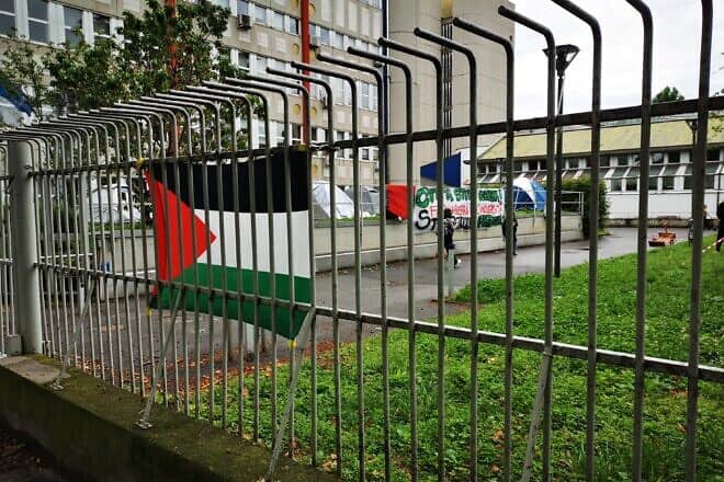 Pro-Palestinian flag and signs at the University of Milan, Italy. Credit: Saggittarius A via Wikimedia Commons.