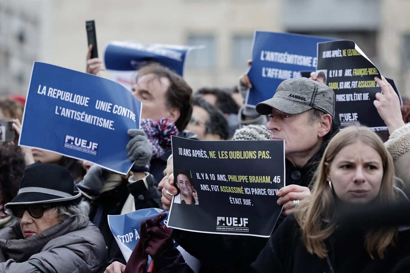Attendees of a rally in France sponsored by the Representative Council of French Jewish Institutions (CRIF) hold signs reading, “The republic united against antisemitism” and “10 years on, let's not forget” outside the Hypercacher kosher market in Paris, in memory of the terrorist attack that took place there a decade ago, on Jan. 9, 2025. Photo by Stephane De Sakutin/AFP via Getty Images.
