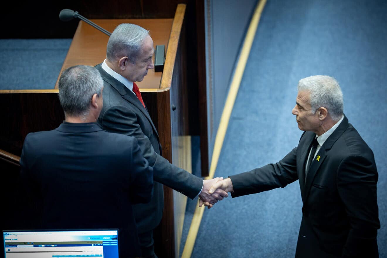 Israeli Prime Minister Benjamin Netanyahu shake hands with Opposition Leader Yair Lapid at a plenum session for Israeli Knesset's 75th birthday, in the assembly hall of the Knesset, the Israeli parliament in Jerusalem, Israel on Jan, 24, 2024. Photo by Yonatan Sindel/Flash90.