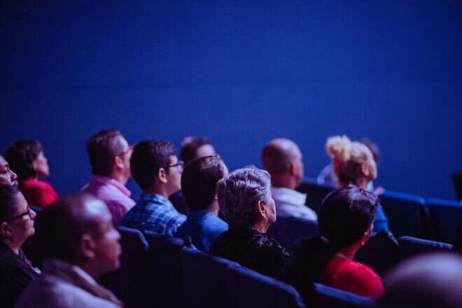 People sitting in a conference hall. Credit: Luis Quintero/Pexels.
