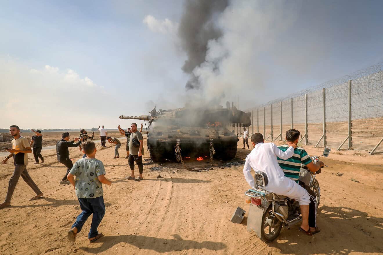 Palestinians take control of an Israeli tank after breeching the border fence from Khan Yunis in the southern Gaza Strip, Oct. 7, 2023. Photo by Abed Rahim Khatib/Flash90.