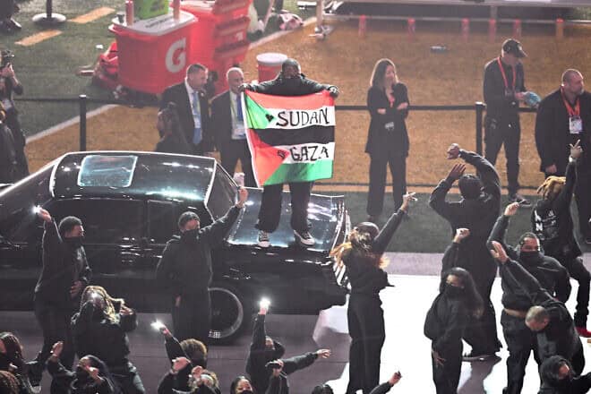 A protester holds a Palestinian flag with the words "Gaza" and "Sudan" as U.S. rapper Kendrick Lamar performs during Super Bowl LIX Chiefs vs Eagles Apple Music Halftime Show at Caesars Superdome in New Orleans, Feb. 9, 2025. Photo by Chandan Khanna/AFP via Getty Images.