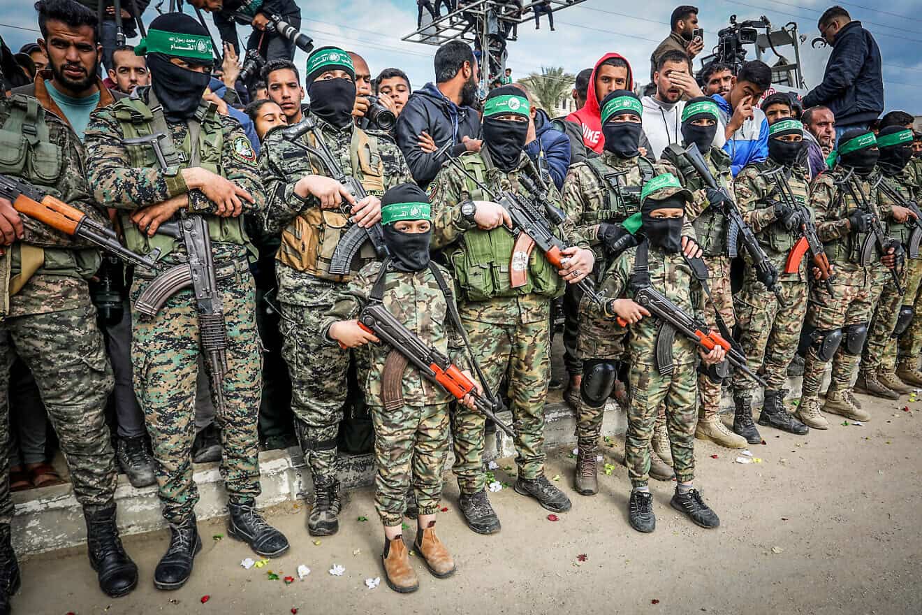Palestinian boys dressed in the Al-Qassam Brigades uniform participate in a handover of Israeli hostages to the Red Cross, in Deir al-Balah, Gaza, Feb. 8, 2025. Photo by Abed Rahim Khatib/Flash90.