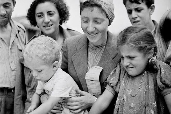 Women and children register for the Fort Ontario Refugee Camp in Oswego, N.Y., August 1944. Credit: Photographer Hikaru Iwasaki for the U.S. Department of the Interior, Public Domain, via Wikimedia Commons.
