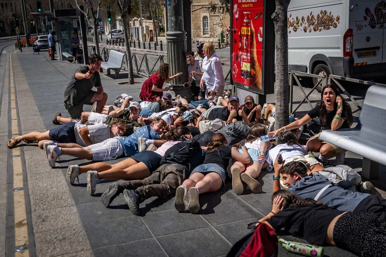 People take cover as sirens warns of incoming missile fire from Yemen in Jerusalem, March 27, 2025. Photo by Chaim Goldberg/Flash90.