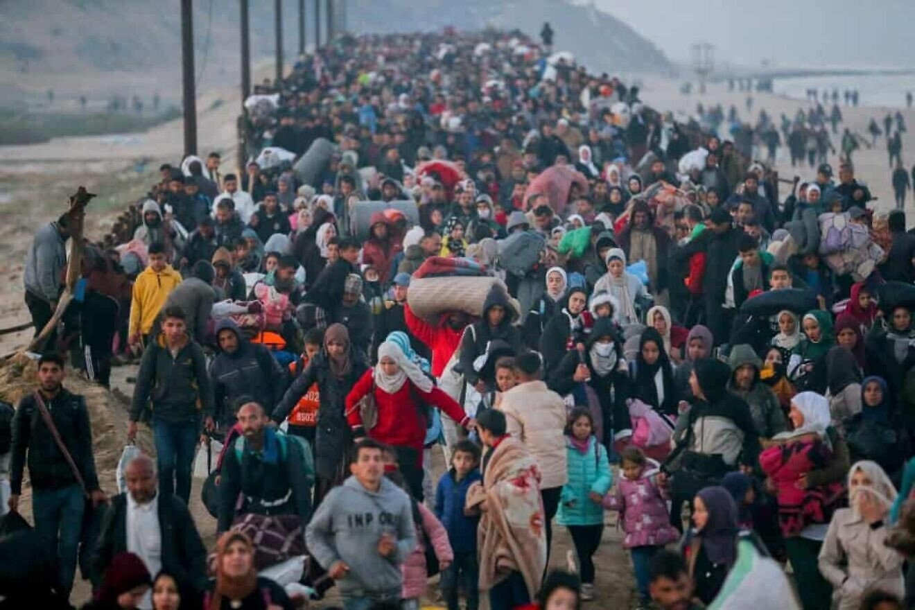Gazans walk north on the al-Rashid Road coastal route to cross the Netzarim Corridor on Jan. 27, 2025. Photo by Youssef Alzanoun/Middle East Images/AFP via Getty Images.