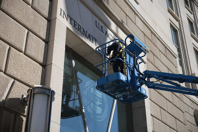 A worker removes the U.S. Agency for International Development sign on its headquarters on Feb. 7, 2025. Photo by Kayla Bartkowski/Getty Images.