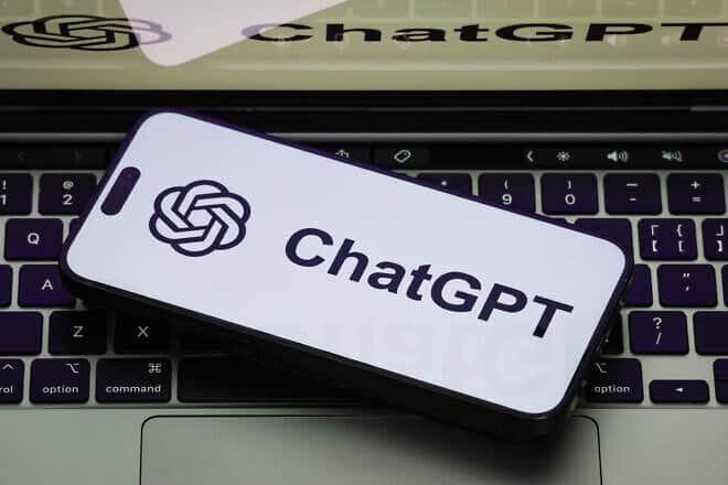 A close-up of a smartphone displaying the ChatGPT logo on a white screen, with the same ChatGPT logo shown on a laptop screen on February 19, 2025 in Chongqing, China. Photo by Cheng Xin/Getty Images.