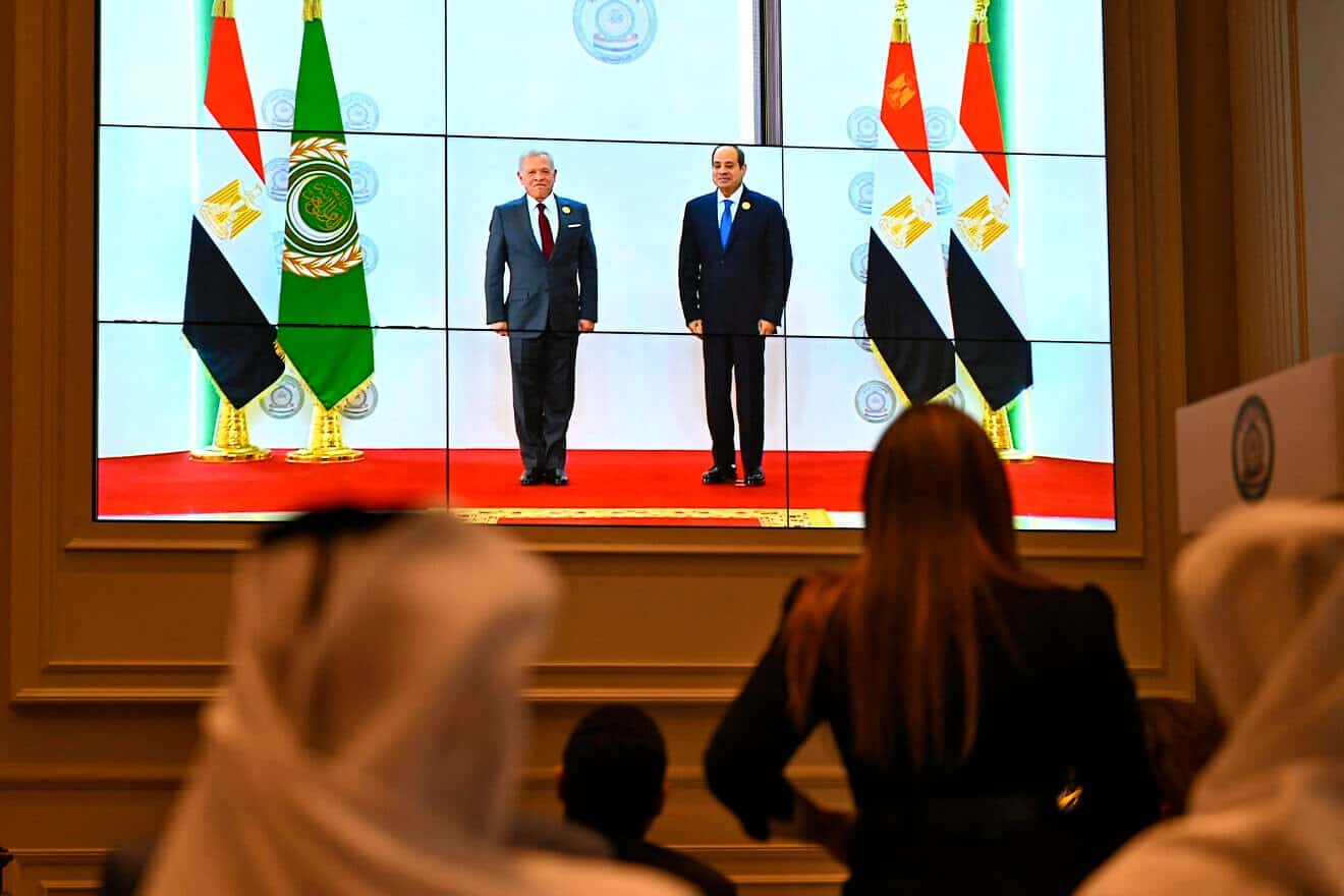 People watch on a big screen as Egyptian President Abdel Fattah el-Sisi (right) welcomes Jordan's King Abdullah II ahead of an Arab League summit on Gaza, on March 4, 2025. Photo by Khaled Desouki/AFP via Getty Images.