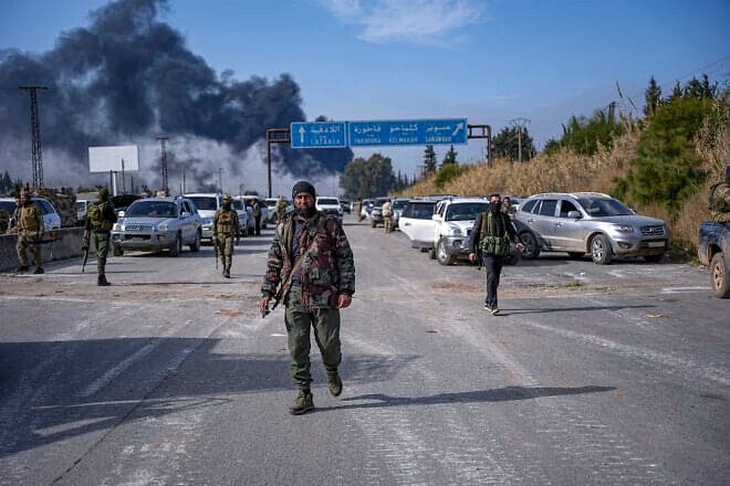 Forces of the new Syrian government's defense ministry and gunmen loyal to former President Bashar Assad battle on outskirts of Jableh in the Latakia countryside, on March 7, 2025. Photo by Mohamad Daboul/Middle East Images/AFP via Getty Images.